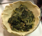 Spread out the thoroughly mixed escarole pie ingredients.
